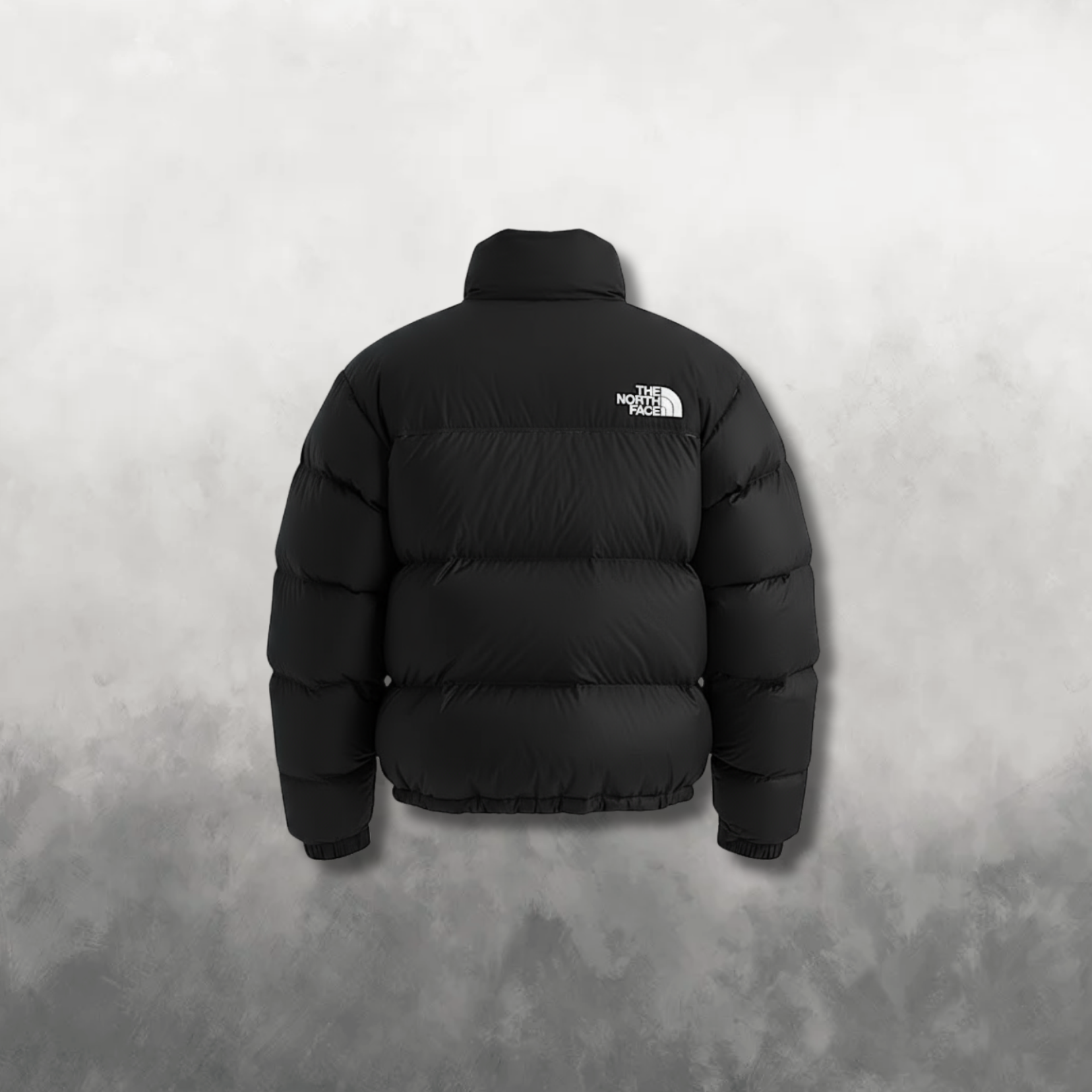 Black puffer jacket with The North Face logo on a gray background