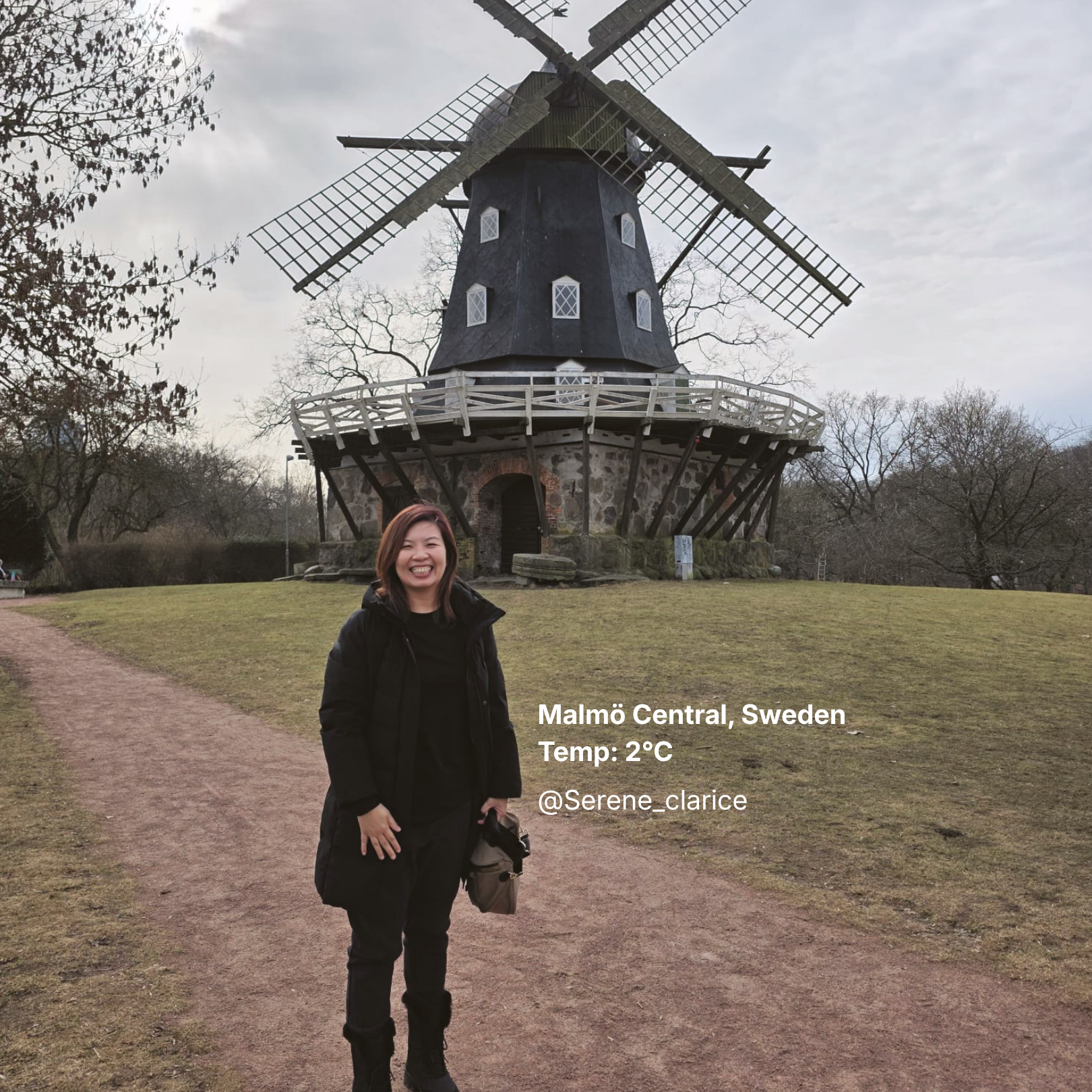 Person in black puffer jacket standing in front of a windmill in Malmö Central, Sweden