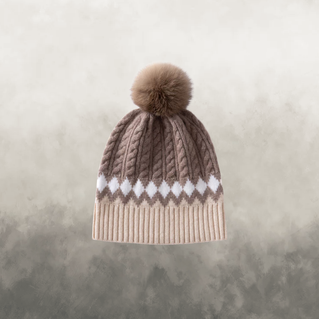 Knitted beanie with a pom-pom on a textured beige background