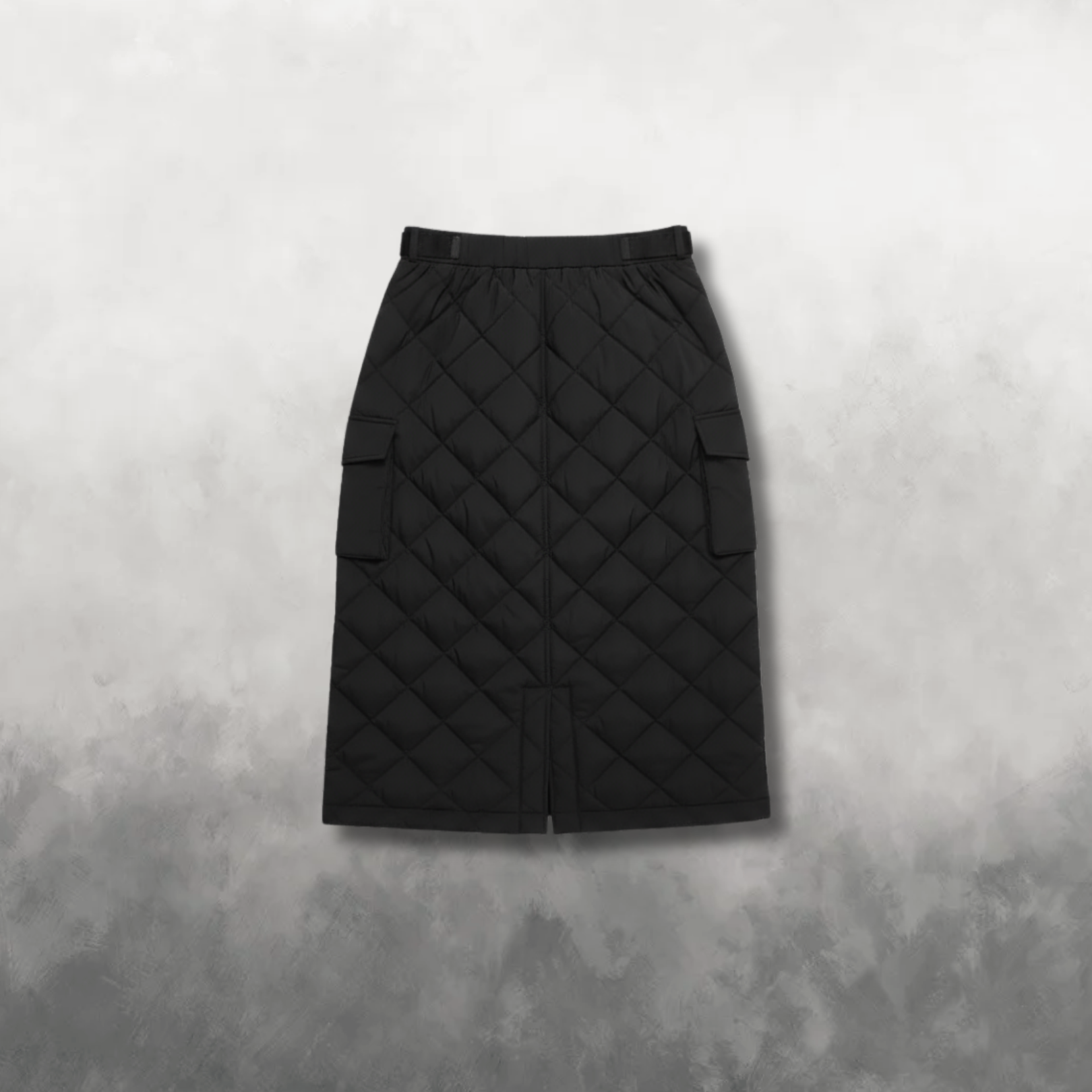 Back view of a black quilted skirt on a textured gray background